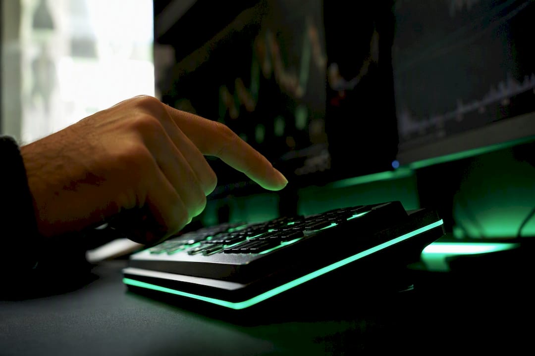 Trader hand poised above neon-lit trading keypad